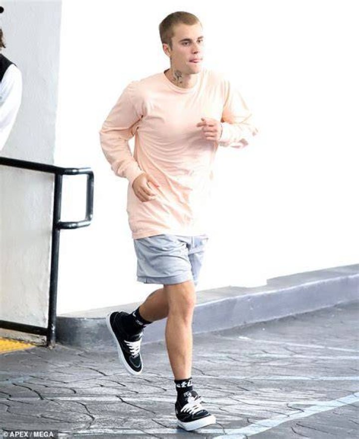 Low key: Justin covered up in a long-sleeve pale peach T-shirt, which he contrasted with gray shorts